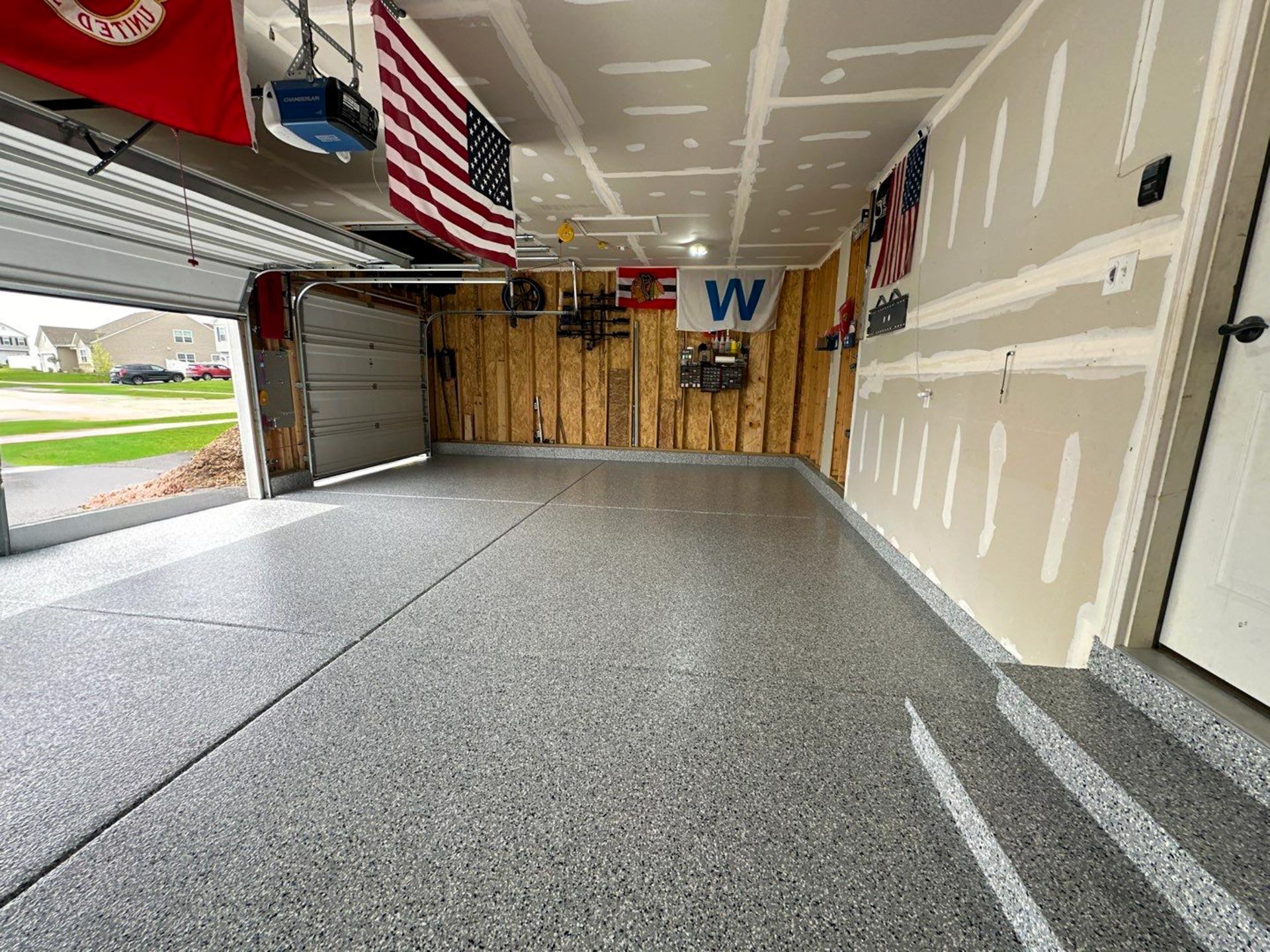 Finished gray flake epoxy garage floor with two cars